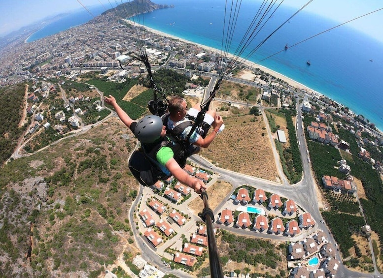 A person skydiving with a parachute over a coastal cityscape. 5