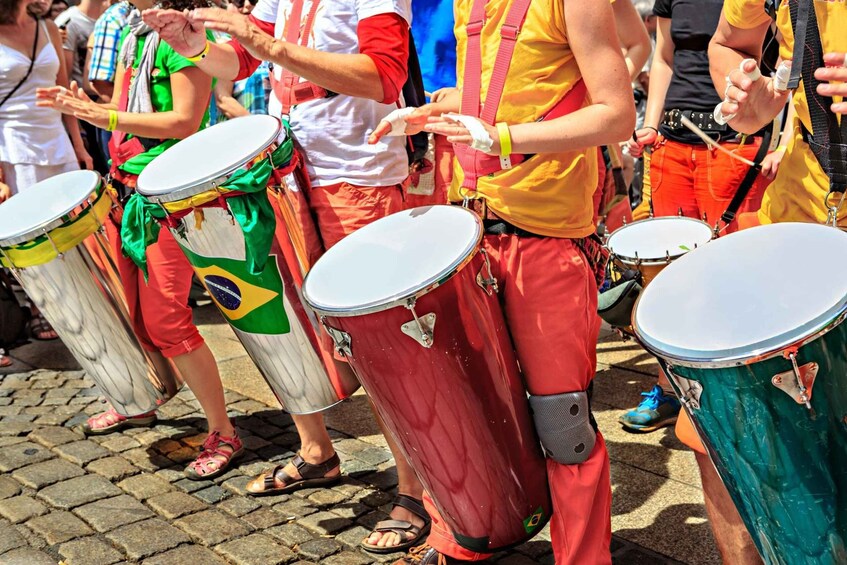 A group of people playing drums in a parade. 2