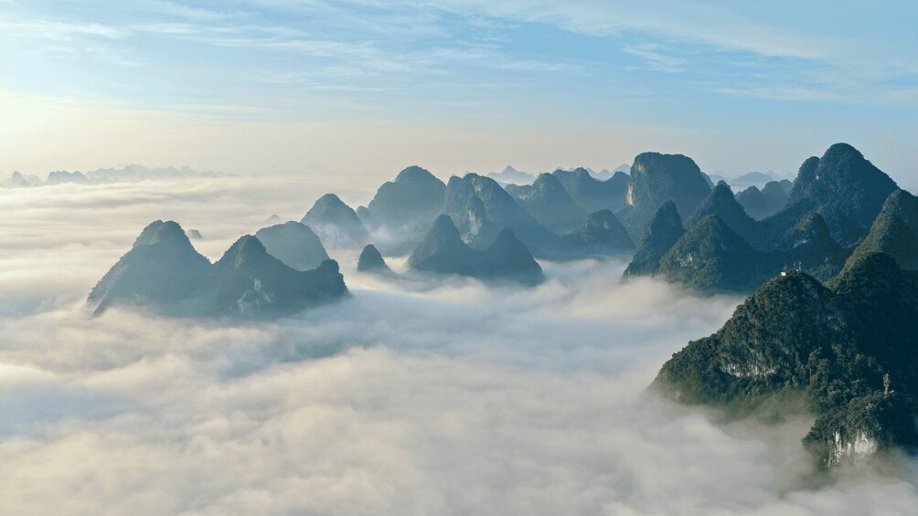 A mountainous landscape with peaks surrounded by clouds. 1