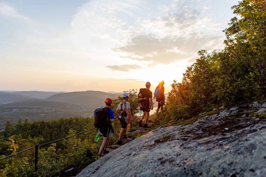 A group of hikers ascending a rocky trail with a scenic view of the landscape. 5