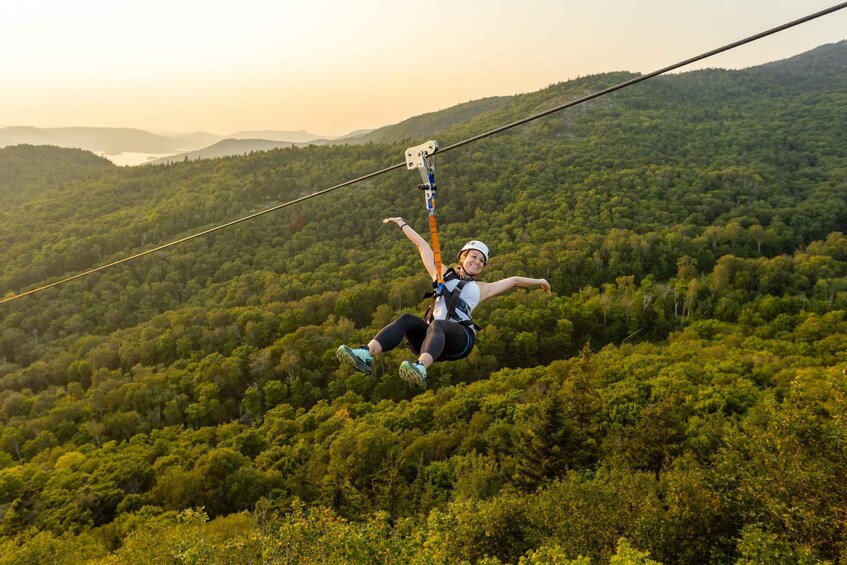A person bungee jumping from a high wire with a forested valley below. 3