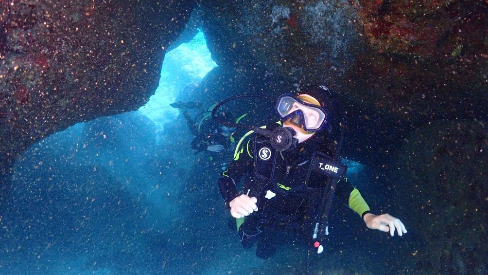 A diver in a cave with a blue light source. 4
