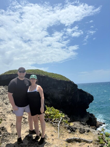 A couple standing on a rocky cliff with ocean views. 4