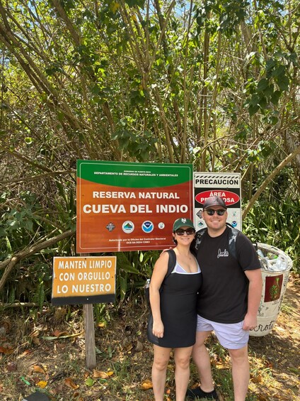 A natural reserve sign, a caution sign, and a trash can. 2