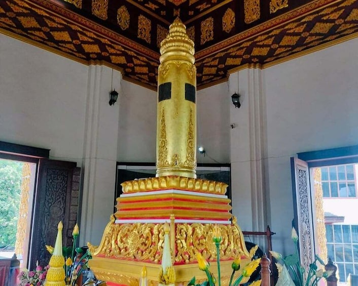 A golden stupa with intricate designs, surrounded by colorful decorations and flowers. 1