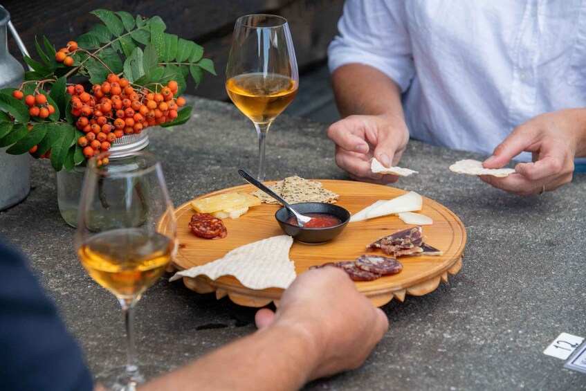 A group of people tasting various cheeses and meats at an outdoor event. 3