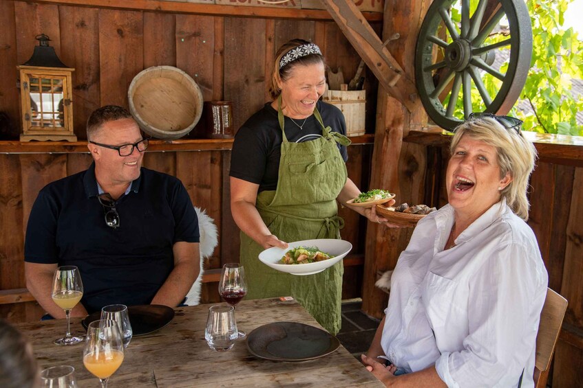 A wooden table with wine glasses and a plate of food. 2