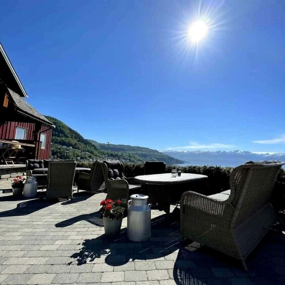 A patio with wicker furniture, a metal table, and a potted plant. 1