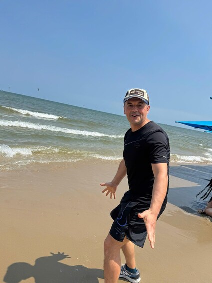 A person on a sandy beach with waves in the background. 2