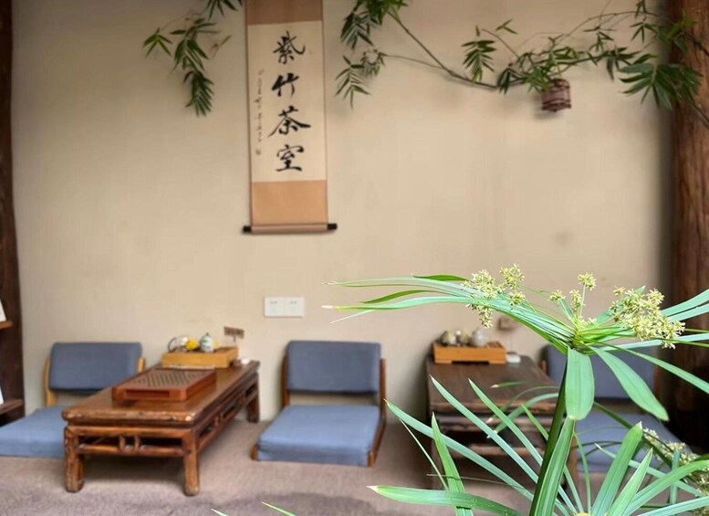A traditional Japanese room with tatami mats, wooden furniture, and a hanging scroll with Japanese characters. 3