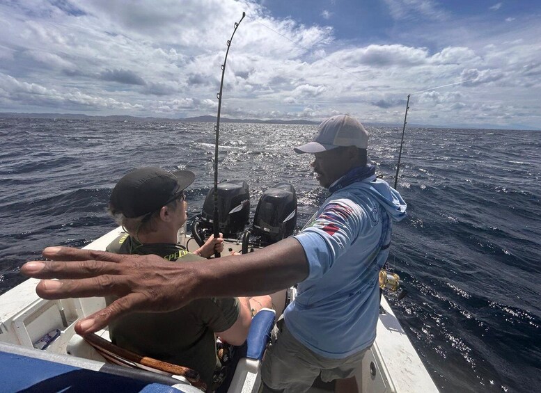 Two people on a boat with fishing rods, ocean water, and a cloudy sky. 3