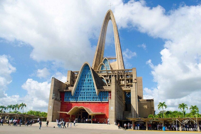 A large, modern building with a distinctive triangular roof and a large arched entrance. 1