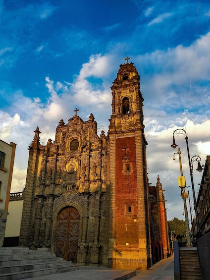 A historic cathedral with intricate architecture, a prominent bell tower, and a large wooden door. 1