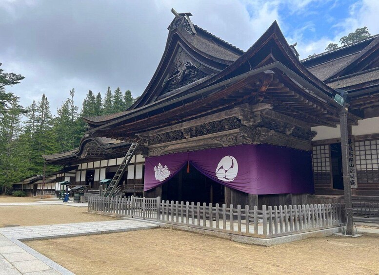 A traditional Japanese building with a purple awning and a wooden fence. 4