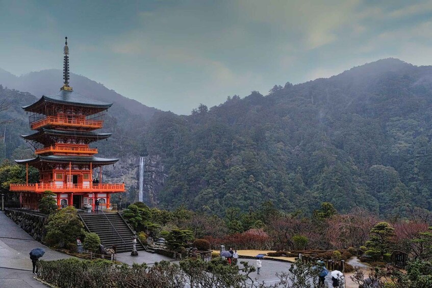 A traditional Japanese pagoda with multiple tiers, surrounded by lush greenery and mountains in the background. 1