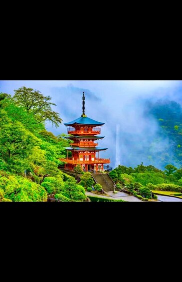 A multi-tiered pagoda surrounded by lush greenery and a misty backdrop. 1