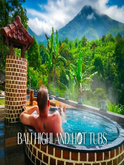 A man relaxing in a hot tub with a mountainous backdrop. 4