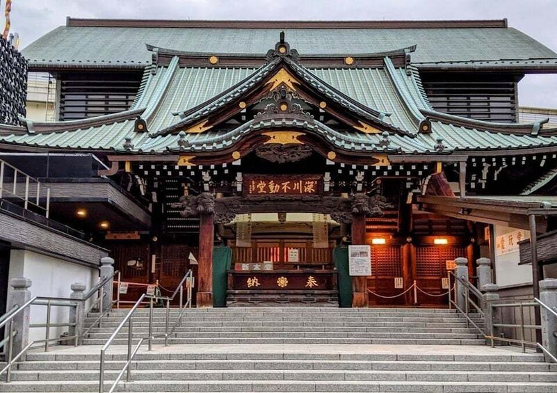 A traditional Japanese building with a tiled roof and a wooden entrance gate. 3