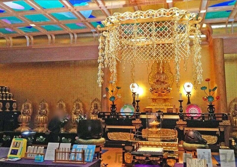 A display of golden statues and jewelry in a well-lit room with a patterned ceiling. 4