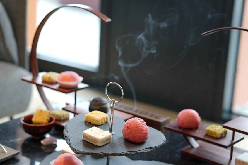 A dessert display with various sweets on a black slate stand. 3