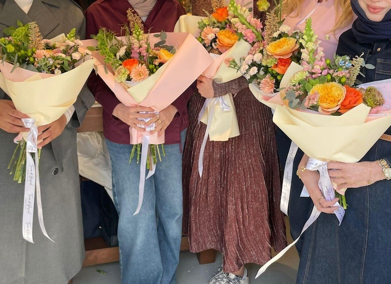 Four individuals holding bouquets of flowers. 4