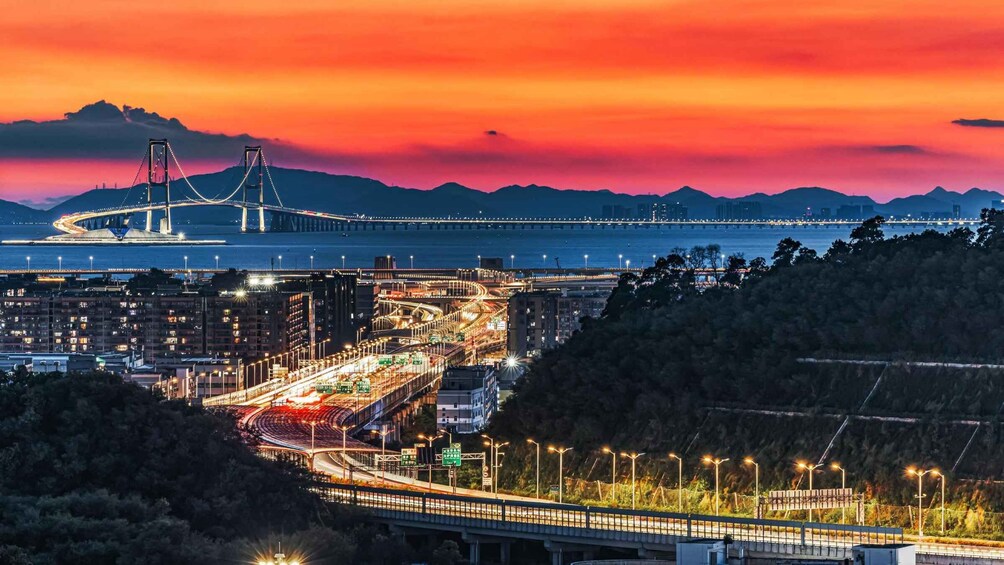 A cityscape at dusk with a prominent bridge and a highway. 5
