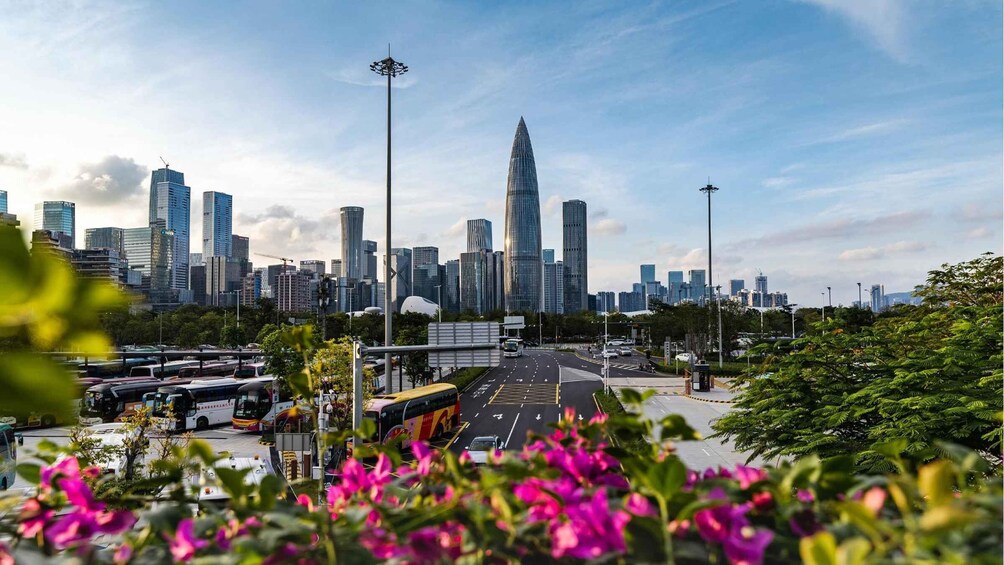 A cityscape with modern skyscrapers, a highway, and a flower-lined foreground. 4
