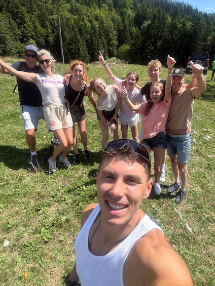 A group of people in a grassy field with trees in the background. 2