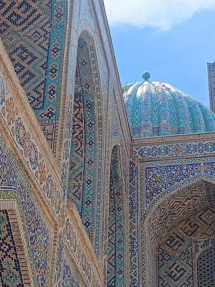 A building with intricate tile work and a large dome. 3