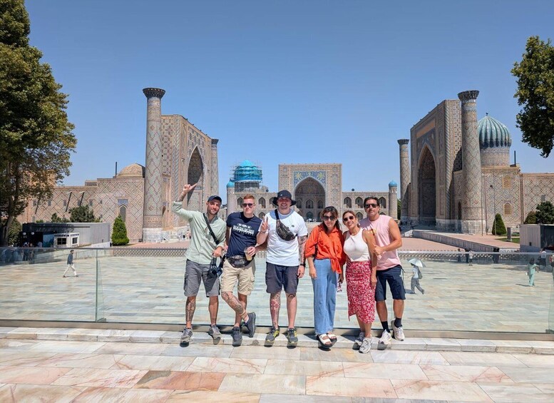 A group of people posing in front of a historic building with intricate tile work and domes. 2