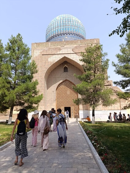 A historic building with a large dome and arched entrance, surrounded by trees and a pathway. 5