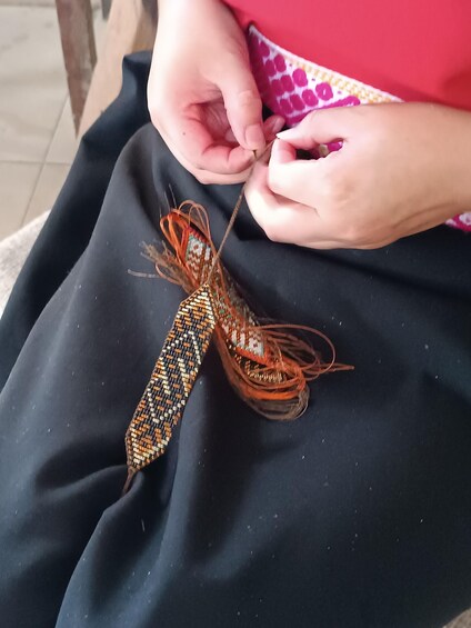A person tying a patterned fabric. 2