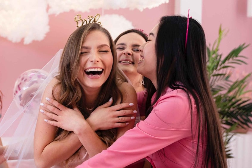 A person wearing a tiara and a veil, hugging another person in a pink outfit. 4