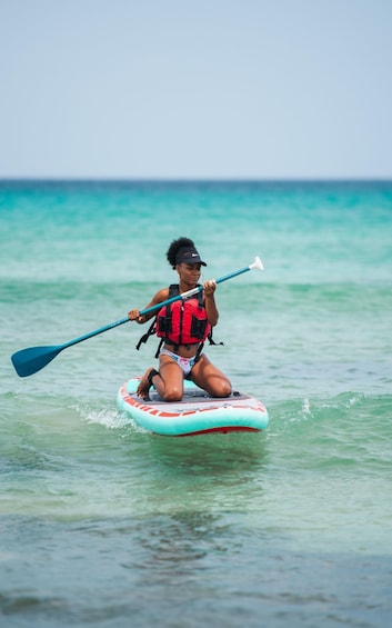 A person kayaking on a turquoise sea. 1