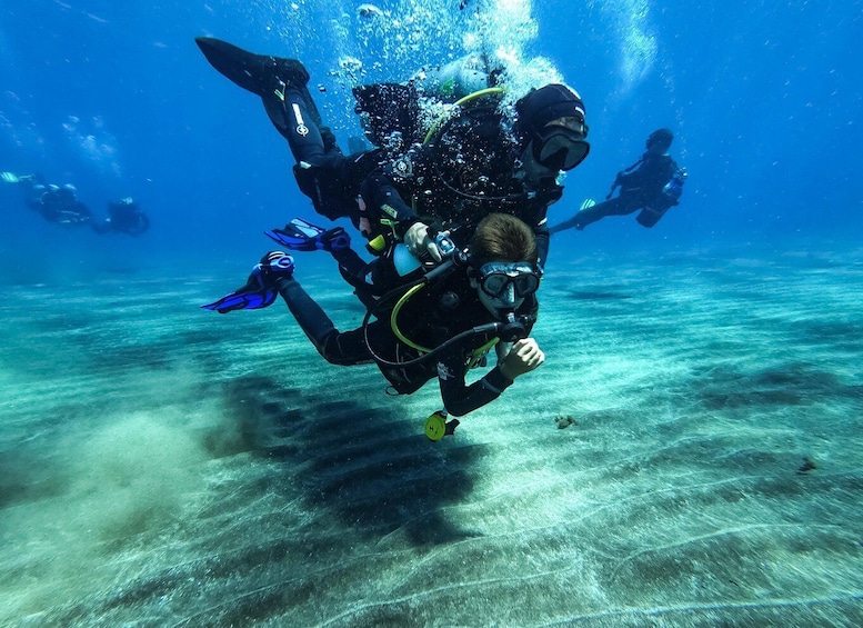 Two scuba divers underwater with bubbles rising to the surface. 2