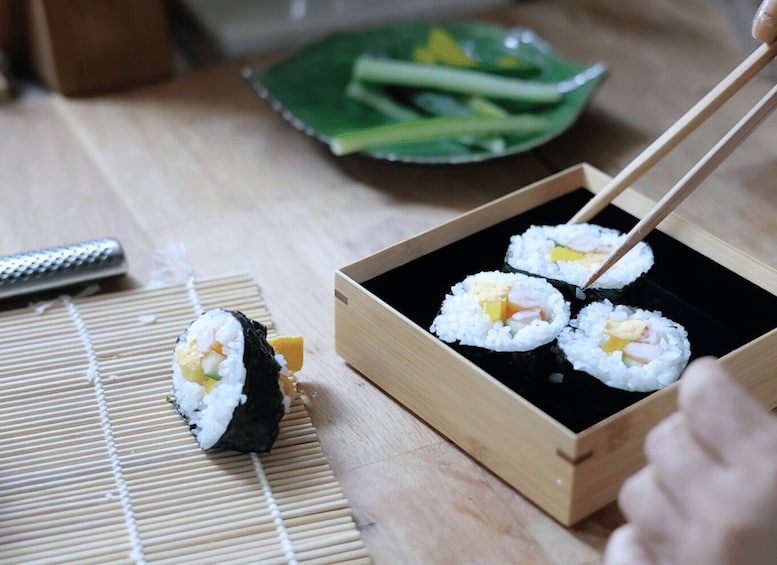 Sushi on a bamboo mat with chopsticks. 2
