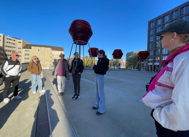 A group of people standing in an urban plaza with modern buildings in the background. 4