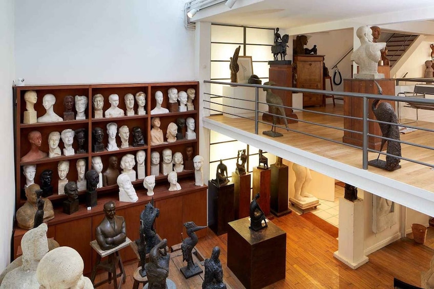 A room with multiple busts on shelves and a statue on a pedestal. 3