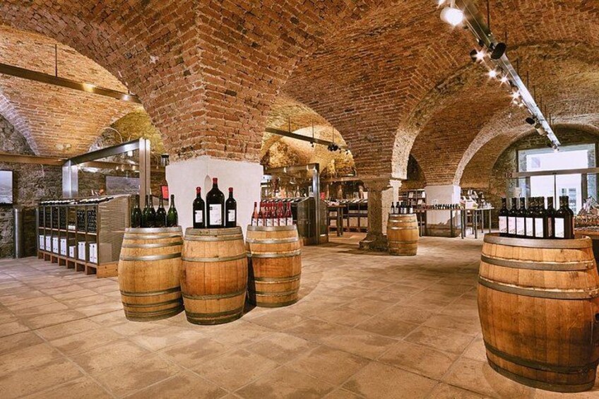 Una bodega con barriles de madera, paredes de piedra y techo de ladrillo. 4