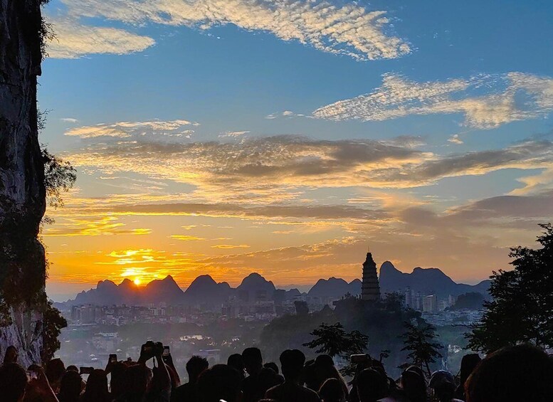 Ein Sonnenuntergang über einer Stadtlandschaft mit Bergen und einem Pagode. 3