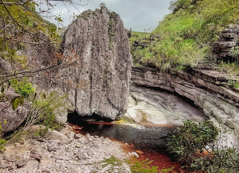 A natural rock formation with a stream flowing through a rocky bed. 2