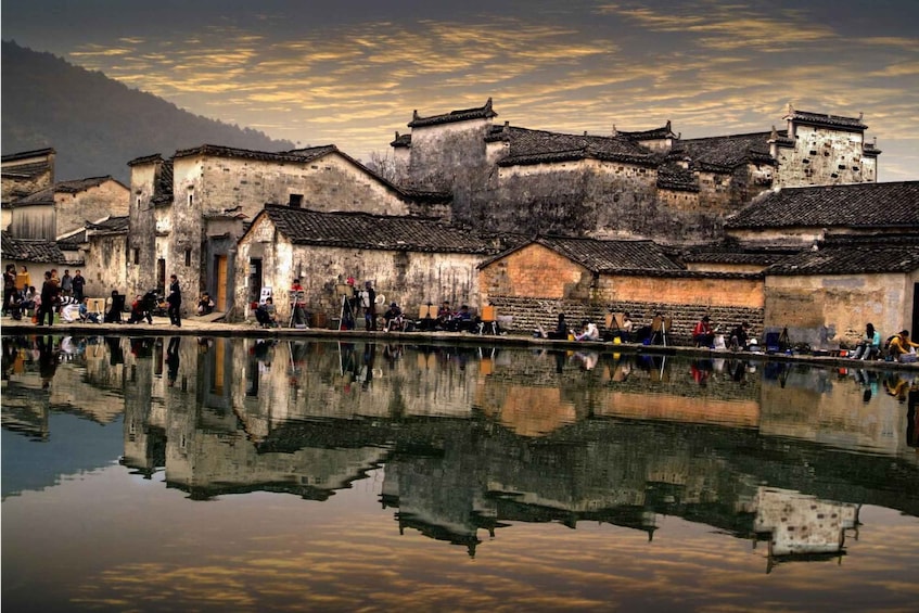 Traditional buildings with a reflective water surface in the foreground. 3