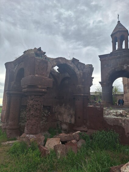 Ancient ruins with arches and a bell tower. 2