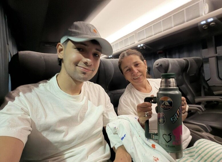 Two people seated in a vehicle with a bottle of water. 4