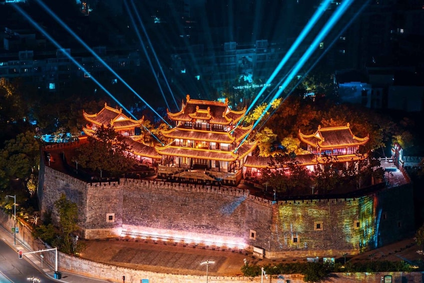 A traditional Chinese building illuminated at night with laser lights. 1