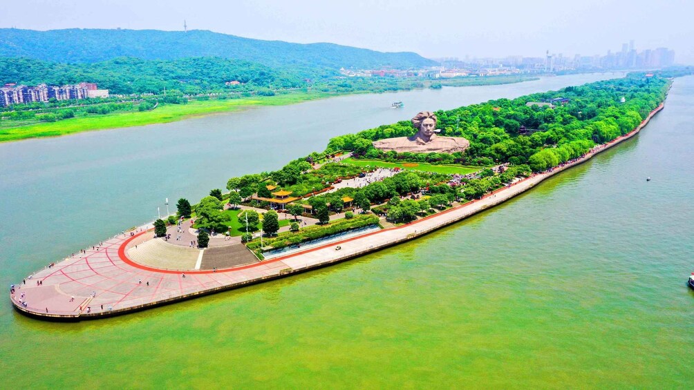 A riverside park with a central monument, walking paths, and a boat dock. 3