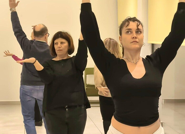 A group of people in a room with one person raising their arms. 2