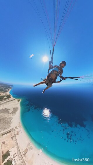 A person skydiving over a coastal area with a clear view of the ocean and beach. 1