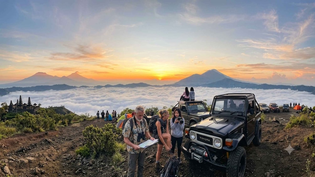 A group of people on a mountain with a sunset, a Toyota vehicle, and a temple in the background. 3
