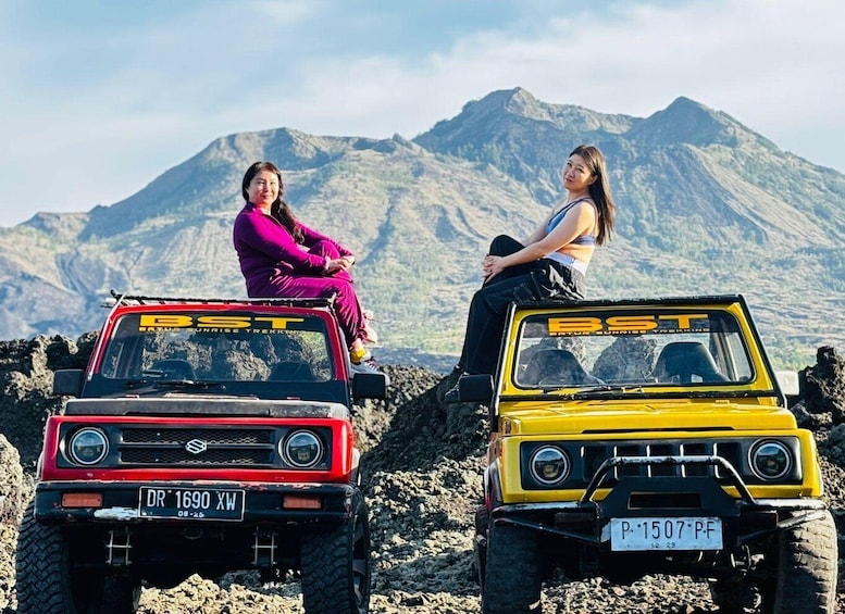 Two off-road vehicles with 'BST' decals parked on rocky terrain with mountains in the background. 5